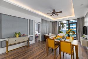 峴港的住宿－Chi House Danang Hotel and Apartment，客厅配有餐桌和大屏幕电视