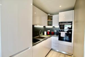 a kitchen with white cabinets and a stove top oven at Sea view Monaco Monte Carlo in Beausoleil