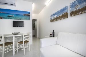 a white living room with a white couch and a table at siciliacasevacanze - Marina Domus in Marina di Ragusa