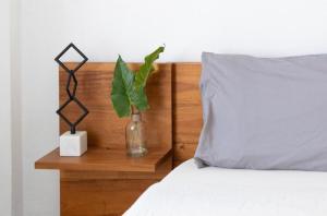 ein Bett mit einem Holzkopf mit einer Vase mit einer Pflanze in der Unterkunft Newely remodeled apartment only 1 min to the beach! in Miami Beach