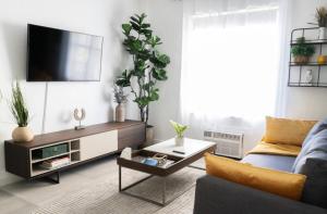 een woonkamer met een bank en een tv bij Newely remodeled apartment only 1 min to the beach! in Miami Beach