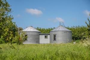 dois edifícios num campo com relva e árvores em Extraordinarily converted grain stores - The Silos em Ipswich