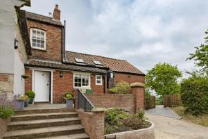 a brick house with a white door and stairs at Lime Kiln Farm in Malton