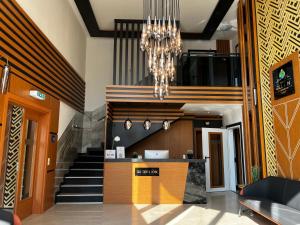 a lobby with a staircase and a chandelier at Hotel Belen Fahrenkrug in Fahrenkrug