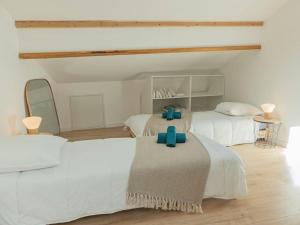 biała sypialnia z 2 łóżkami z niebieskimi krzyżami w obiekcie Les Rives Bleues - atypique et climatisé - 2 salles d'eau - Wifi w mieście Albi