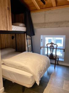a bedroom with two bunk beds and a chair at Zarautz Surf House in Zarautz