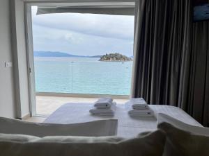 a room with a bed with a view of the ocean at Nelly's Apartments in Tolo