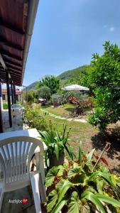 a white chair sitting on a porch with plants at Katerina Fotopoulos Rooms & Apartments - Papanero com in Agios Ioannis Pelio