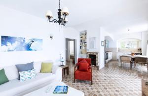 uma sala de estar com um sofá branco e uma cadeira vermelha em Villa Ruyam em Marmaris
