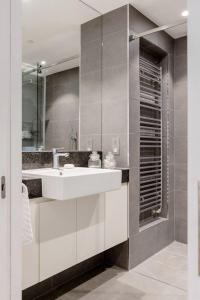 bagno con lavandino bianco e specchio di Lovely room a Londra