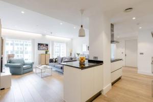a white kitchen and living room with a couch at Home Stay - Coven Garden in London +7 photos