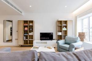 a living room with a couch and a chair and a tv at Home Stay - Coven Garden in London