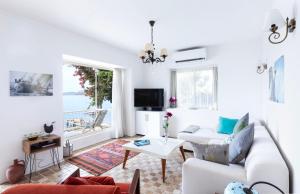 Sala de estar blanca con sofá y mesa en Villa Ruyam en Marmaris