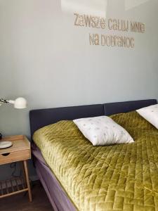 1 dormitorio con 1 cama con un cartel en la pared en Mieszkanie na Tumskiej, en Płock