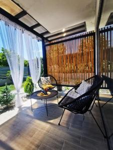 eine Terrasse mit Stühlen, einem Tisch und einem Zaun in der Unterkunft Blue Breeze in Sinemorets