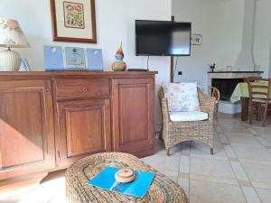 a living room with a wooden entertainment center and a tv at Sa Domixedda in Villasimius