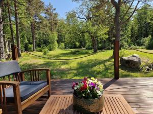 a wooden deck with a table with flowers on it at Elulille maja mere läheduses Lahemaa rüpes in Andineeme