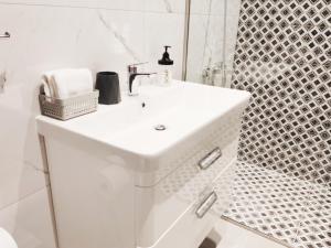 a white bathroom with a sink and a shower at Acropolis Oasis by YHA in Athens