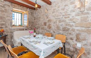 a dining room with a white table and chairs at Stunning Home In Kaprije With Wifi And 2 Bedrooms in Kaprije