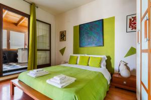 Mini Appartamento verde في غالّيبولي: غرفة نوم بسرير اخضر عليها مناشف