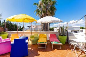a group of chairs and umbrellas on a patio at Mini Appartamento verde in Gallipoli