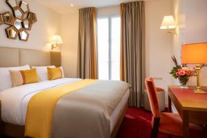 una camera d'albergo con letto e scrivania di Hotel De Suede Saint Germain a Parigi