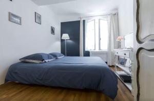a bedroom with a blue bed in a white room at Le Fersen - cosy studio- coeur vieil Antibes in Antibes
