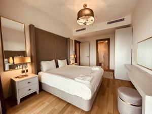 伊斯坦堡的住宿－Maslak Aparts，卧室配有一张白色大床和镜子