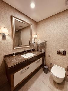 a bathroom with a sink and a toilet and a mirror at Maslak Aparts in Istanbul