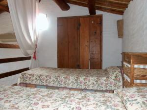 una camera con 2 letti e un armadio in legno di Domus Antiga Appartamenti a San Giovanni Suèrgiu