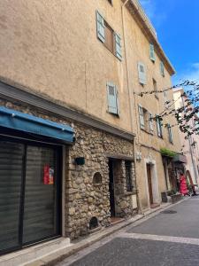 a brick building with a garage on the side of a street at Le Fersen - cosy studio- coeur vieil Antibes in Antibes