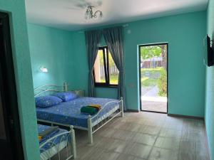 1 dormitorio con paredes azules y 1 cama con almohadas azules en Guesthouse Pekan, en Pitsunda