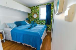 um quarto com uma cama com um edredão azul em Island of Heron - Dolce Vita em Drage