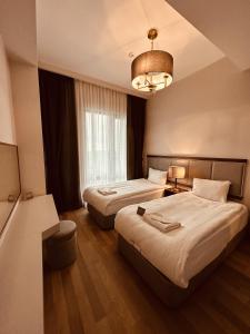 a hotel room with two beds and a chandelier at Maslak Aparts in Istanbul