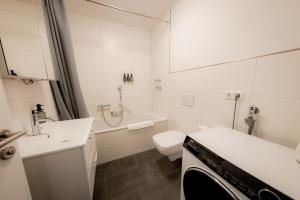 a white bathroom with a toilet and a sink at BONNYSTAY l Modern l Zentral l Work Space l Kitchen l Smart TV l WLAN in Passau +32 photos
