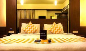 ein Schlafzimmer mit einem großen Bett mit orangefarbenen und weißen Kissen in der Unterkunft FabHotel Prime Ivy Studio in Pune