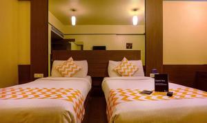 dwa łóżka w pokoju hotelowym z znakiem między nimi w obiekcie FabHotel Prime Ivy Studio w mieście Pune