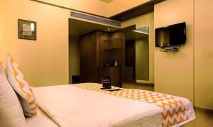 a bedroom with a bed and a tv in it at FabHotel Prime Ivy Studio in Pune