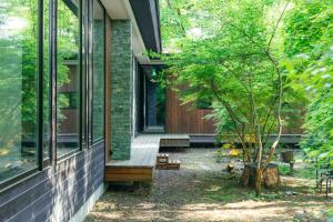 a renovation of a house with a tree in the yard at La Maison Karuizawa in Karuizawa