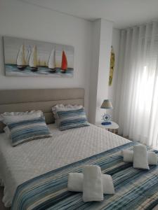 a bedroom with a large bed with two pillows at Apartamento Estrela do Mar in Nazaré