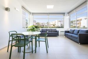 een woonkamer met een tafel en stoelen en een bank bij Dunas Hostel & Guesthouse in Alvor