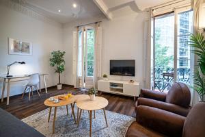 sala de estar con sofá y mesa en Habitat Apartments Eixample Balconies., en Barcelona