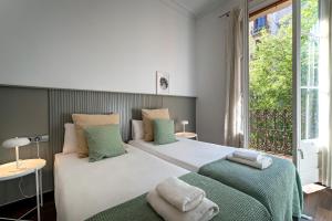 バルセロナにあるHabitat Apartments Eixample Balconies.のベッドルーム1室(ベッド2台、大きな窓付)