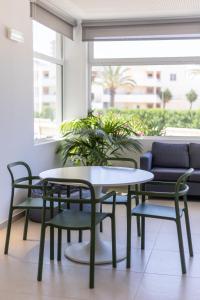 einen Tisch und Stühle in einem Zimmer mit Sofa in der Unterkunft Dunas Hostel & Guesthouse in Alvor