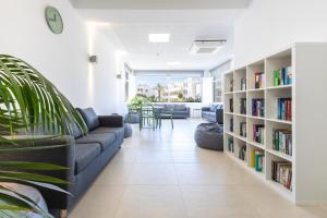 een woonkamer met een bank en boekenplanken bij Dunas Hostel & Guesthouse in Alvor
