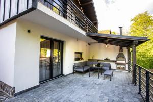 a patio with a table and chairs and a balcony at Cabana Armonia in Baia-Sprie