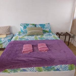 uma cama com duas toalhas cor-de-rosa em cima em PARAÍSO TOM DO MAR 2 em Arraial do Cabo