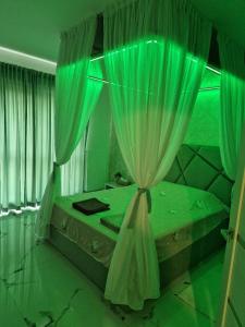 a green bedroom with a bed with a curtain at XMX Jacuzzi and Baldachin Studio in Bucharest