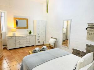 1 dormitorio con cama, tocador y espejo en CASA ISABEL CENTRO Histórico, en Arucas