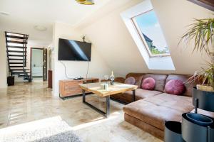 a living room with a couch and a table at Apartament Ukiel z widokiem na jezioro in Olsztyn